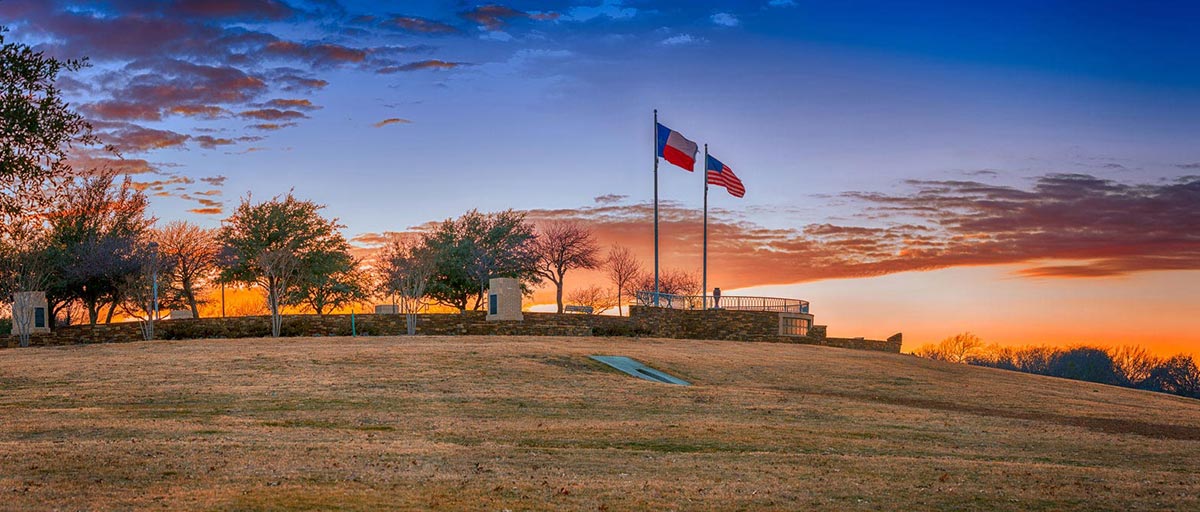 Flags flying in a field at sunset in Frisco Texas