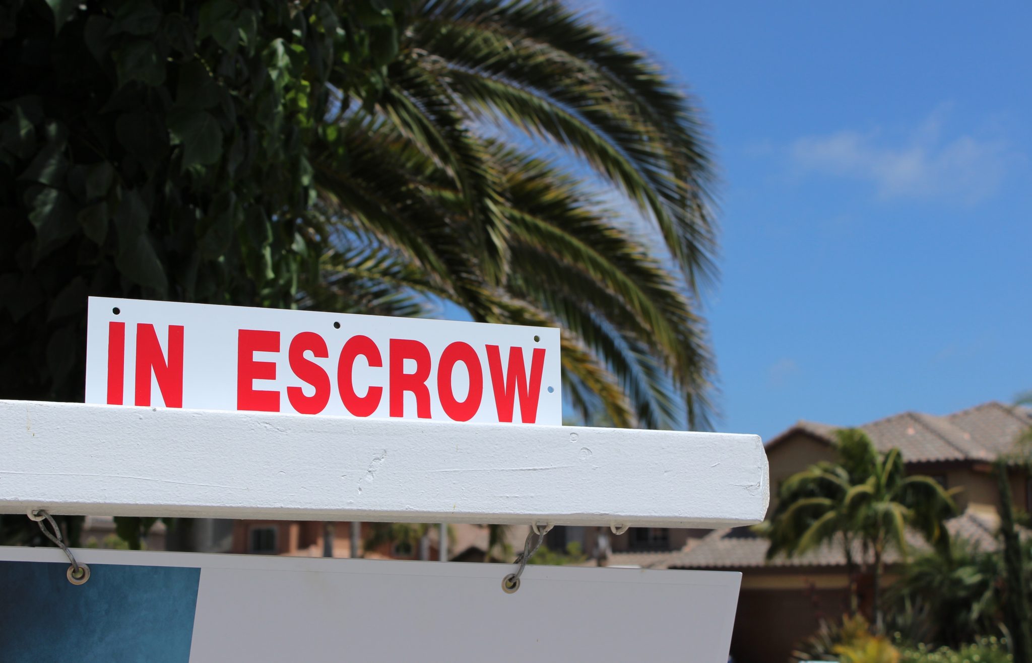 In escrow sign in front of house.
