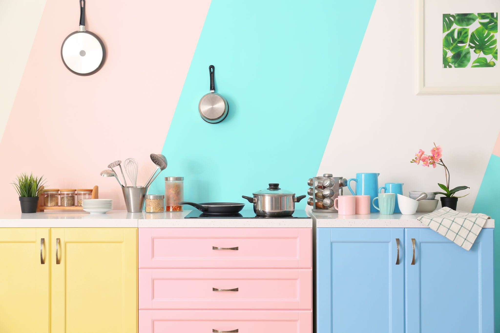 Yellow, pink, and blue kitchen cabinets with pink and blue striped walls. (Hint: the best kitchen paint colors aren't any of these!)